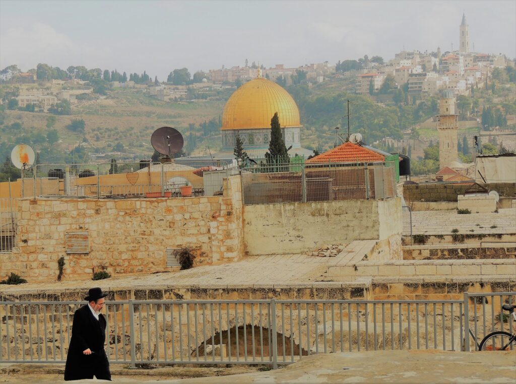 Jewish person walking in Jerusalem with Al Aqsa mosque in the background